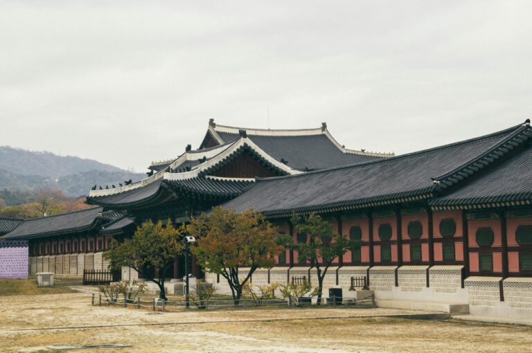 Traditional Korean palace (Hanok) architecture set against a modern Seoul skyline, mixing culture and city travel.