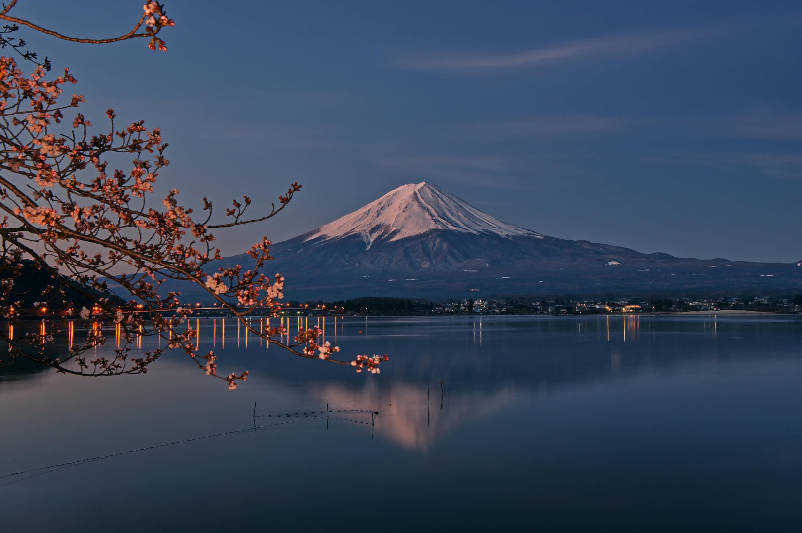 Majestic Mount Fuji rising above a traditional Japanese village, capturing the beauty of Japan travel.