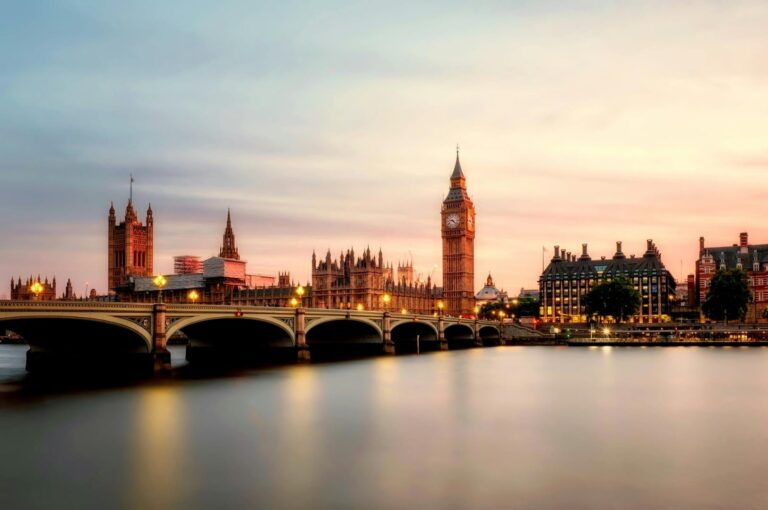 Famous Big Ben clock tower and Houses of Parliament illuminated at night in London, UK travel destination.