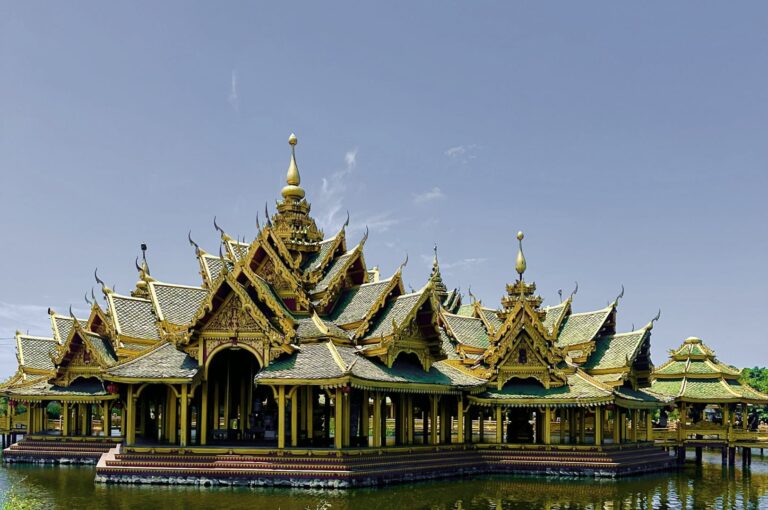 Golden Thai Buddhist temple (Wat) architecture reflected in still water, perfect for Southeast Asia travel.